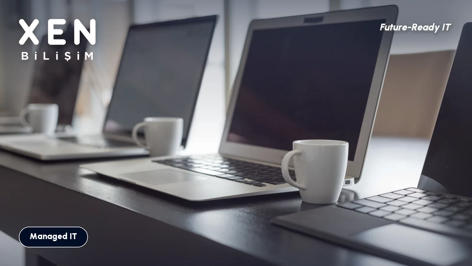 Laptops lined up and ready on a long table — Xen Bilişim